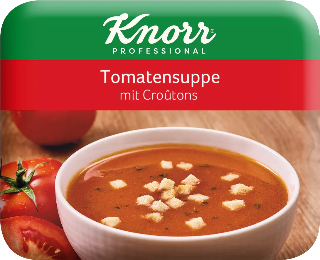 Tomatensuppe mit Croutons in weißer Schale, frische Tomaten im Hintergrund