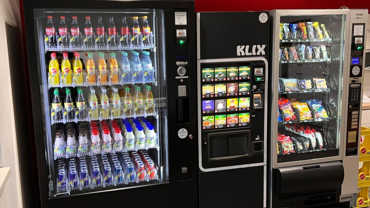 Drei Verkaufsautomaten mit Getränken, Snacks und Kaffee in Innenraum, Automatenaufstellung